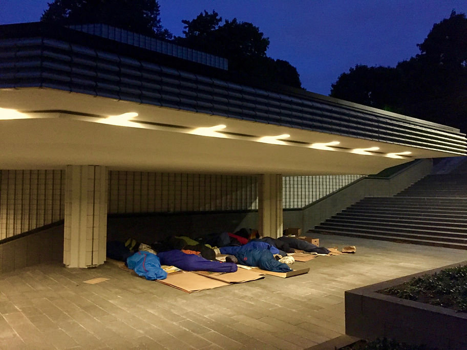 Sleeping on cardboard under an awning.